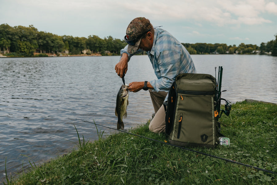 Unhooking a bass beside the AnglerPack