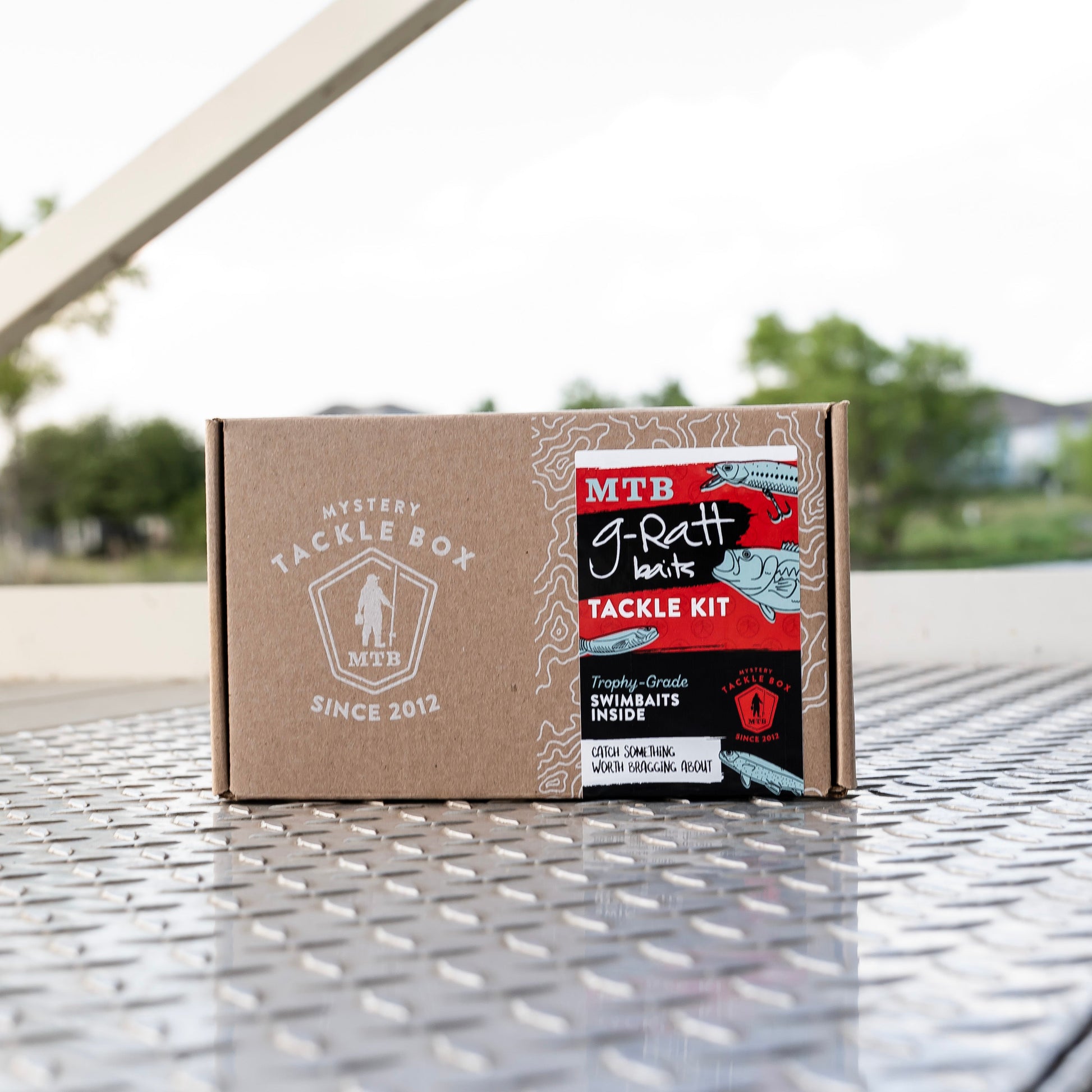 Tackle kit box on a metal surface with blurred outdoor background