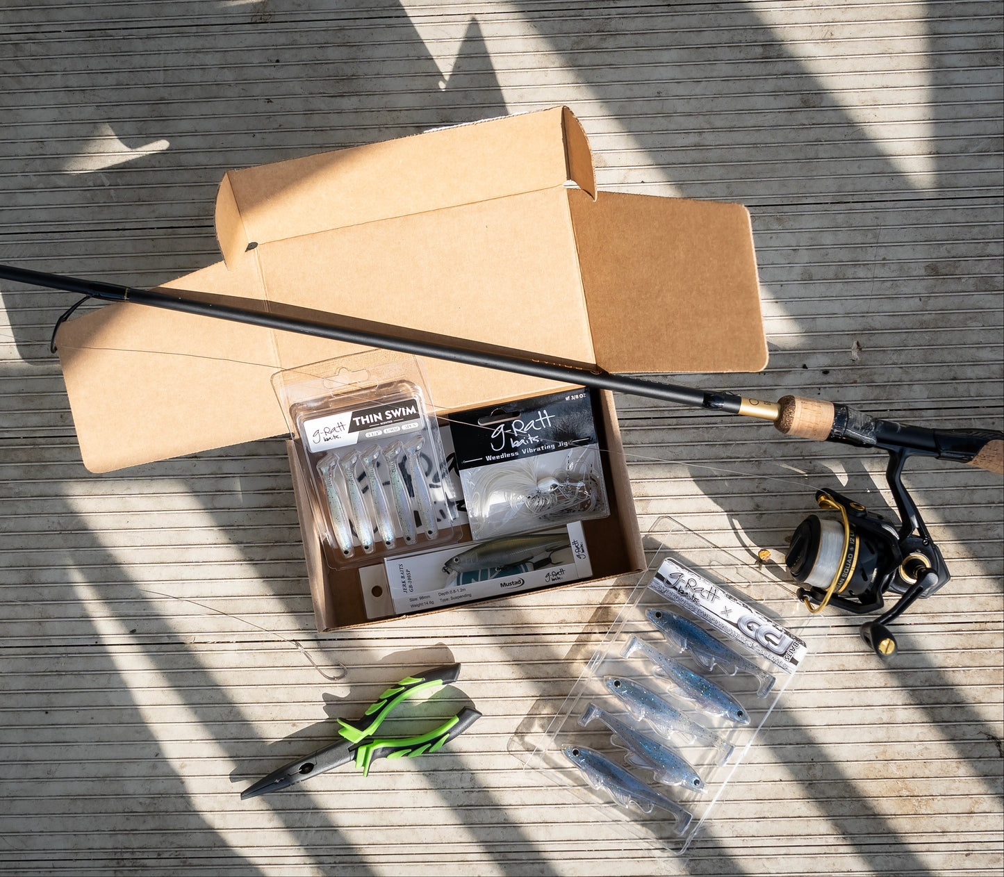 Fishing rod, reel, and accessories on a wooden surface