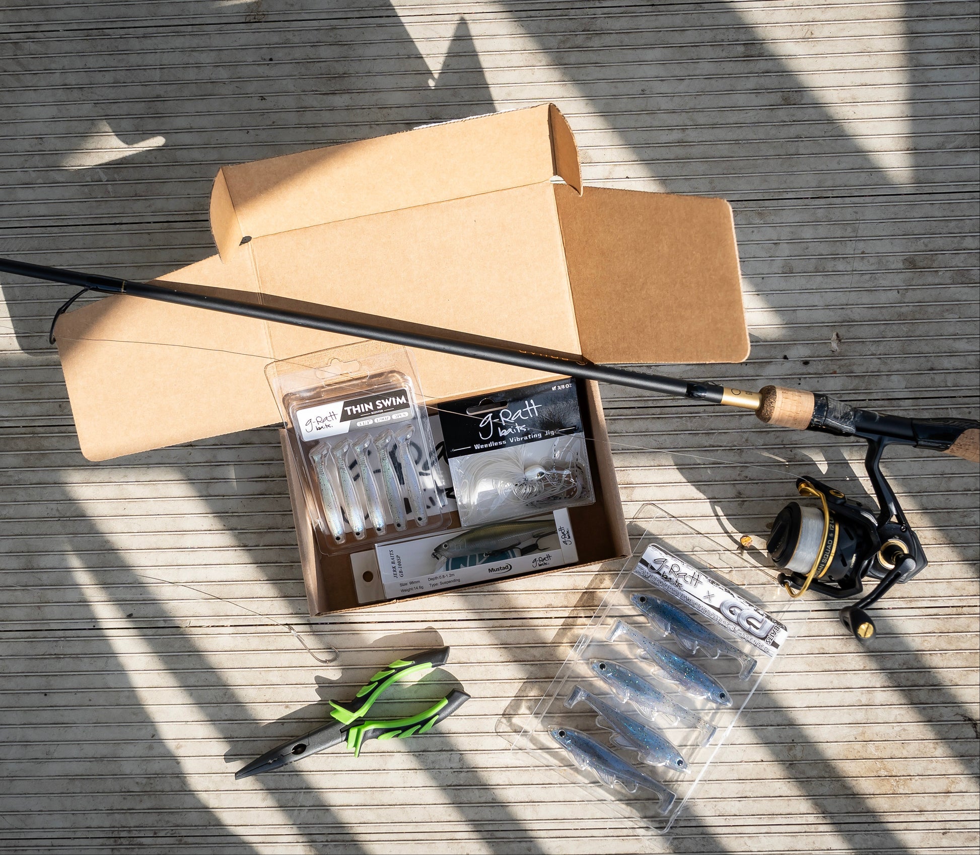 Fishing rod, reel, and accessories on a wooden surface